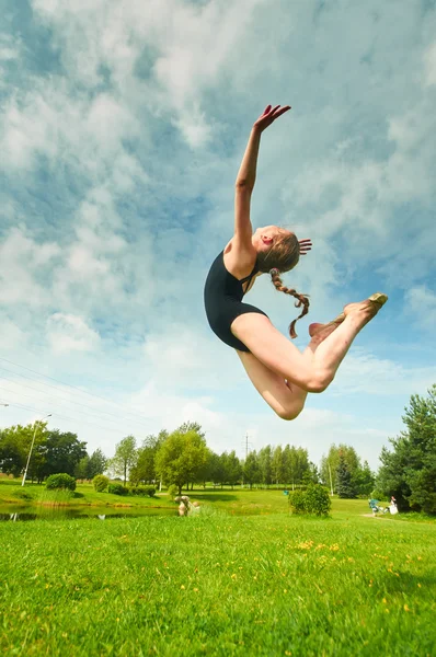 Young beautiful preteen girl doing gymnastics outdoors — Stock Photo, Image