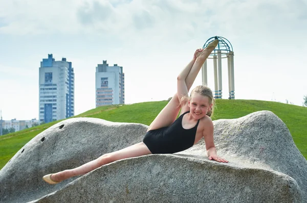 Young beautiful preteen girl doing gymnastics outdoors — Stock Photo, Image