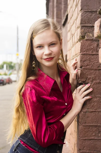 Jonge vrouwelijke tiener meisje pose tegen een bakstenen muur. — Stockfoto