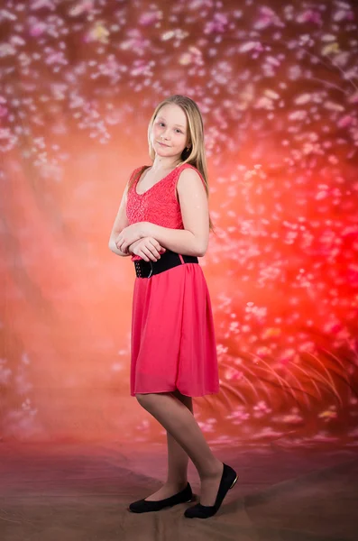 Jovem em vestido vermelho pose no estúdio — Fotografia de Stock