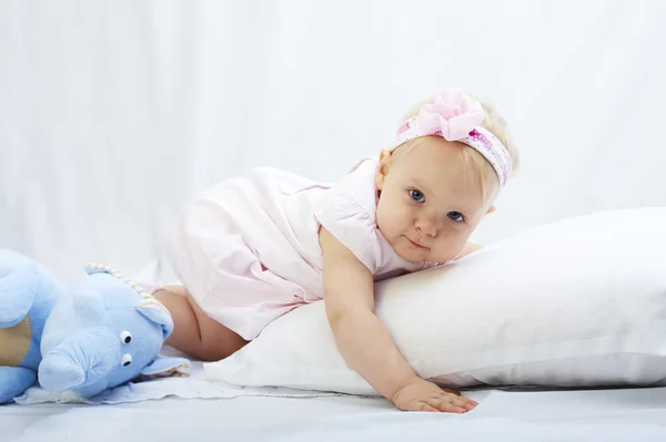 Bebé está jugando con almohada sobre fondo blanco — Foto de Stock