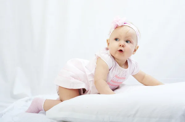 Dítě hraje s polštářem nad bílým pozadím — Stock fotografie