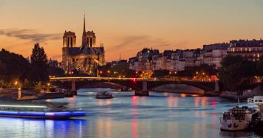 Notre Dame de Paris Katedrali, Ile Saint Louis ve Seine Nehri alacakaranlıkta. Paris 'in 4. Arrondissement bölgesindeki şehir ışıkları ve Sully Köprüsü ile bir yaz akşamının zaman aşımı. Fransa