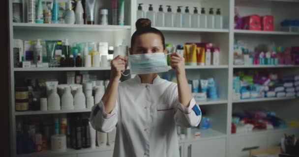 Γυναίκα γιατρός φοράει ιατρική μάσκα και χαμογελάει. Ασφάλεια για τους γιατρούς στην εργασία έννοια. Αντίχειρας. — Αρχείο Βίντεο
