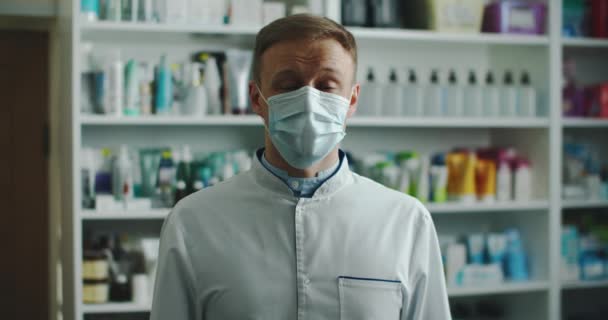 El hombre farmacéutico con una máscara médica cuenta diferentes hechos. Retrato masculino de cerca — Vídeo de stock
