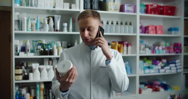 Un pharmacien d'une pharmacie conseille un client par téléphone. Appel téléphonique. — Video