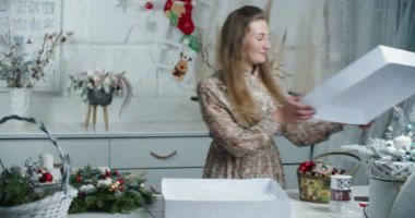 Bir kadın satıcı güzel bir Noel çelengini satılık bir kutuya koyuyor. Noel hediyesi