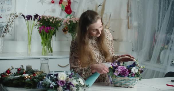 Female hand with sprayer and beautiful bouquet of flowers. Woman seller in flower shop refreshing bouquet with water in basket — Vídeo de Stock