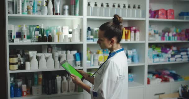 Pharmacie fille utiliser un ordinateur tablette pour vérifier le stock de pharmacie dans sa pharmacie, cette image peut utiliser pour l'hôpital, clinique, laboratoire et concept Internet — Video