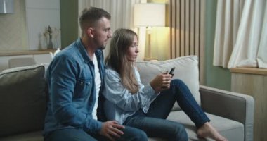 Karı koca koltukta oturuyor ve zafere seviniyorlar. Zaferin onuruna duygular ve jestler.