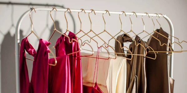Şık moda kadın kıyafetleri mağazadaki bir askıda asılı duruyor. Satılık giysiler