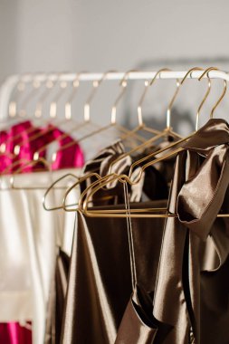 Şık moda kadın kıyafetleri mağazadaki bir askıda asılı duruyor. Satılık giysiler