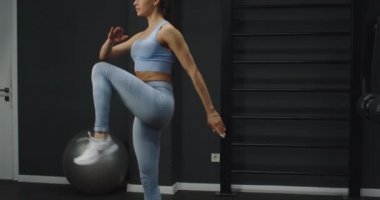 Spor salonunda egzersiz yapan mavi takım elbiseli bir kız. Bir salgından sonra kilo vermek.