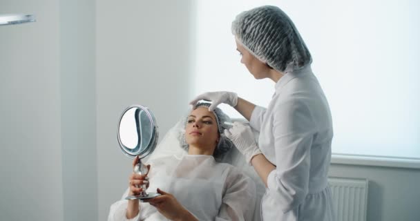 Пластичний хірург готується до операції на обличчі жінки . — стокове відео