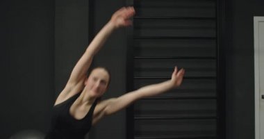 Spor salonunda egzersiz yapan mavi takım elbiseli bir kız. Bir salgından sonra kilo vermek.