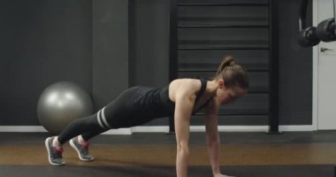 Spor salonunda egzersiz yapan mavi takım elbiseli bir kız. Bir salgından sonra kilo vermek.