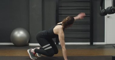 Spor salonunda egzersiz yapan mavi takım elbiseli bir kız. Bir salgından sonra kilo vermek.