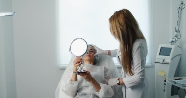 Chirurg plastyczny przygotowujący się do operacji na kobiecej twarzy. — Wideo stockowe