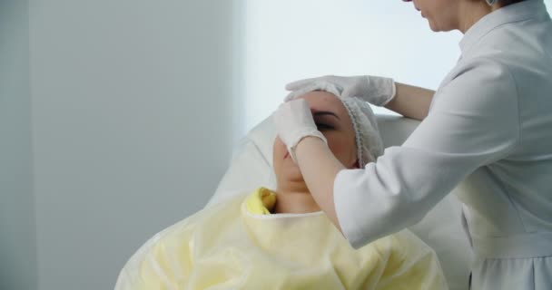 Chirurgien plastique se préparant à l'opération sur le visage de femme. — Video