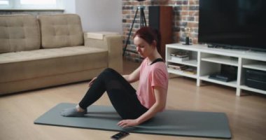 Ev fitness konsepti. Dayanıklılık antrenmanı yapan kadın karın kasları vücut ağırlık egzersizleri yapıyor..