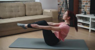 Ev fitness konsepti. Dayanıklılık antrenmanı yapan kadın karın kasları vücut ağırlık egzersizleri yapıyor..