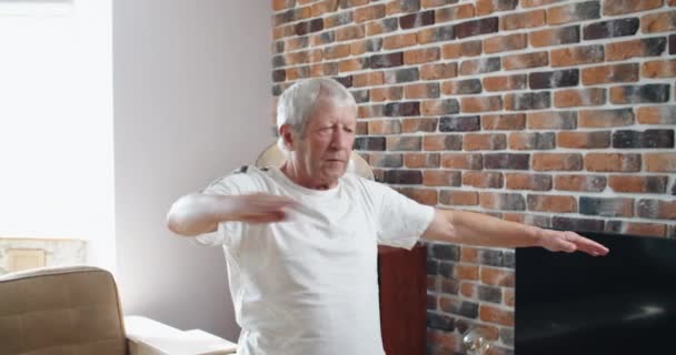 Старший красивий спортсмен робить вправи для розтягування і балансування йоги вдома — стокове відео