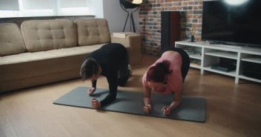 Evde antrenman. Sportif adam yoga yaparken çevrimiçi özel ders izliyor, oturma odasında egzersiz yapıyor, boş yer var.