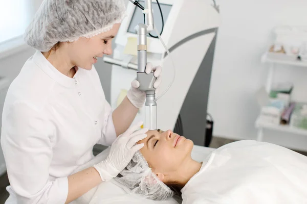 Cosmetology. Closeup Of Female Face having facial treatment in beauty salon. Cosmetic procedures in spa clinic. — Stock Photo, Image