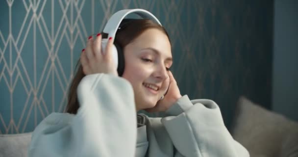 Hermosa chica sonriente escuchando música. Mujer alegre en grandes auriculares disfrutando de la vida. — Vídeo de stock