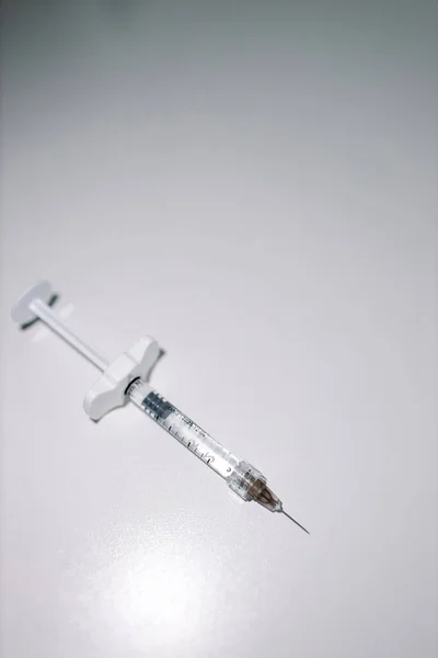 Uma seringa médica com fundo cinzento. Seringa com líquido no interior — Fotografia de Stock