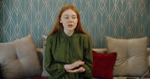 Tråkig ung kvinna med rött hår kommunicerar via videolänk. Tråkiga nyheter — Stockvideo