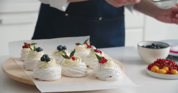 La muchacha del cocinero rocía el glaseado sobre el postre fresco de arándanos. Dulces postres caseros con crema en una bandeja. Comida para el desayuno. Gastronomía y cocina. — Vídeos de Stock