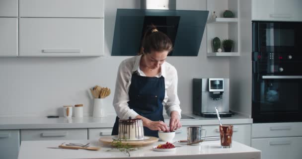 Mulher pasteleiro chef decora bolo de chocolate com bagas, close-up. Processo de fabricação de bolos, foco seletivo — Vídeo de Stock