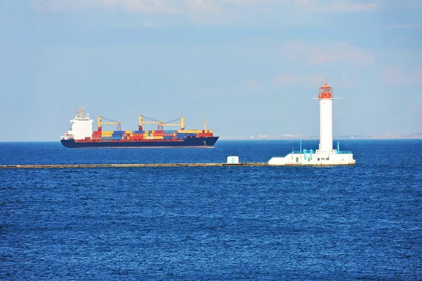 Vrachtschip in de buurt van de vuurtoren — Stockfoto