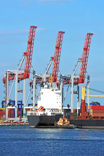 Tugboat assisting container cargo ship — Stock Photo, Image