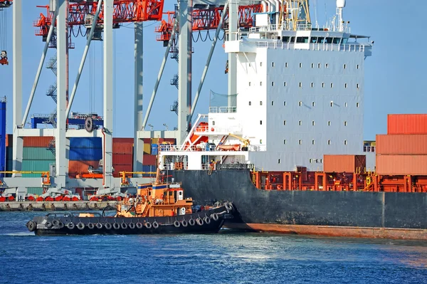 Tugboat assisting container cargo ship — Stock Photo, Image