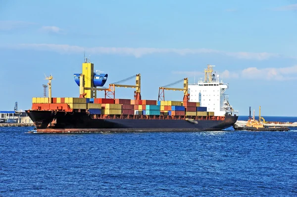 Tugboat assisting container cargo ship — Stock Photo, Image