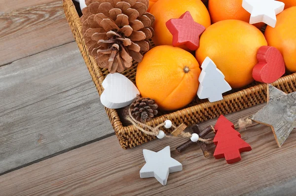 Orange in wickered tray with Christmas decor — Stock Photo, Image