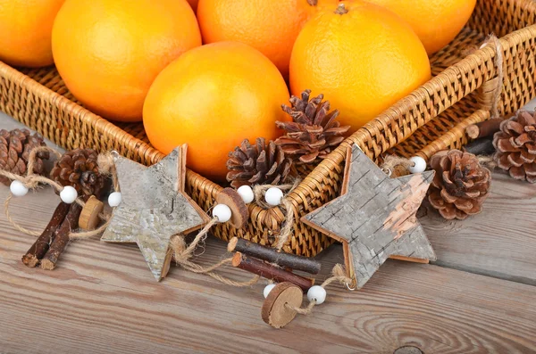 Orange in wickered tray with Christmas decor — Stock Photo, Image