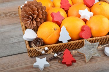 Orange in wickered tray with Christmas decor clipart