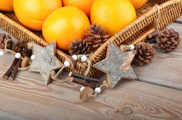 Orange in wickered tray with Christmas decor — Stock Photo, Image