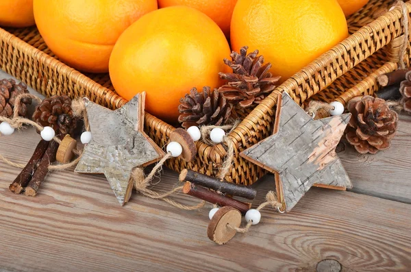 Orange in wickered tray with Christmas decor — Stock Photo, Image