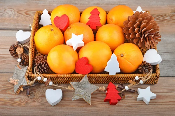 Orange in wickered tray with Christmas decor — Stock Photo, Image