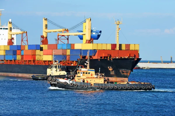 Tugboat assisting container cargo ship — Stock Photo, Image