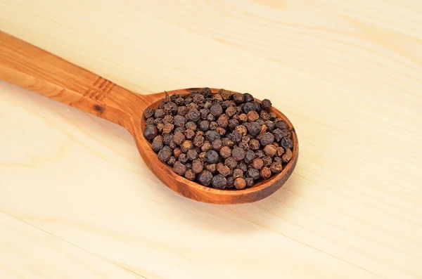 Zwarte peper korrels in houten lepel — Stockfoto