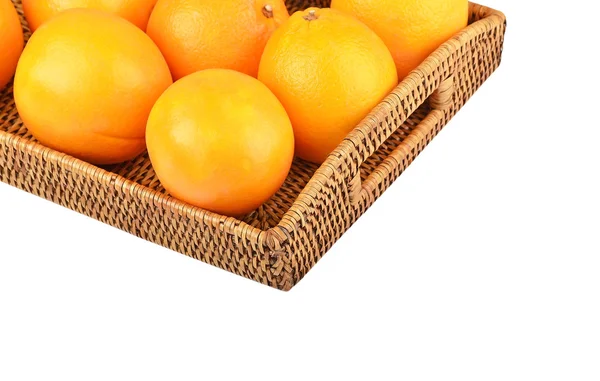 Апельсин на плетеном подносе — стоковое фото