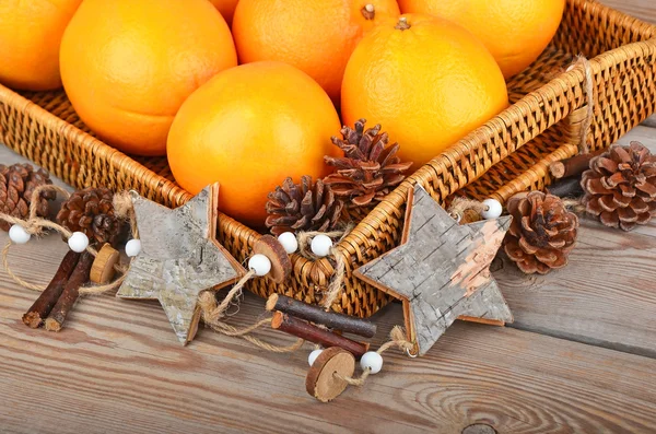 Orange in wickered tray with Christmas decor — Stock Photo, Image