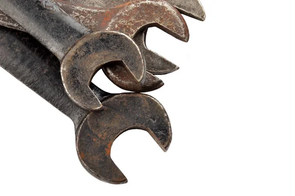 Paslı İngiliz anahtarı yığını, beyaz arka planda izole edilmiş.