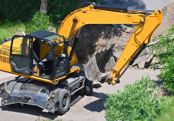 Work of excavating machine on building construction site