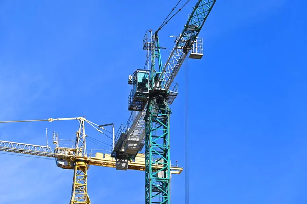青い空に背の高い建設タワークレーン — ストック写真